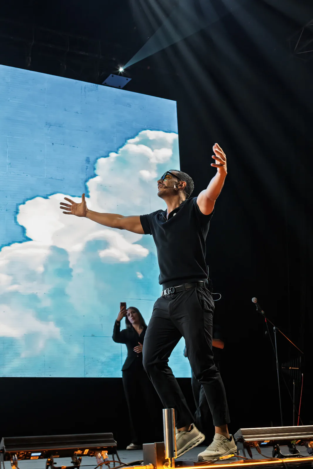 Diek Power en el escenario frente a una pantalla de nubes